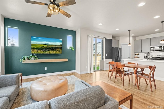 living room with recessed lighting, light wood-type flooring, baseboards, and ceiling fan