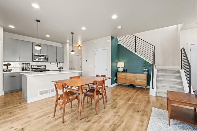 dining room featuring recessed lighting, light wood-style flooring, stairs, and visible vents