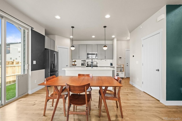 dining area with light wood-style flooring, recessed lighting, and baseboards