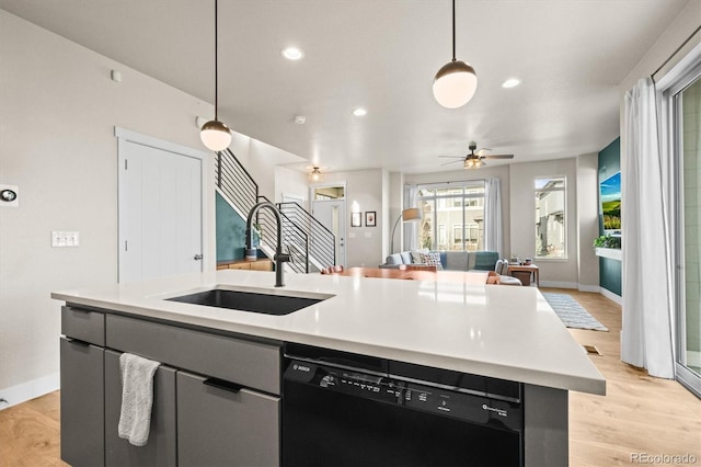 kitchen with an island with sink, a sink, open floor plan, light wood-style floors, and dishwasher