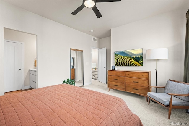 bedroom featuring visible vents, light carpet, ensuite bath, and ceiling fan