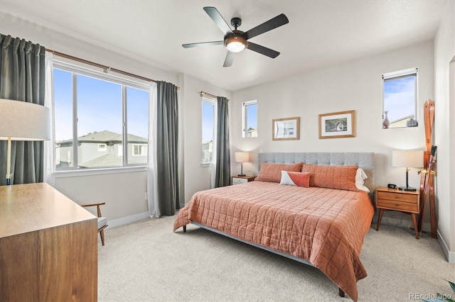 bedroom with light carpet, a ceiling fan, and baseboards