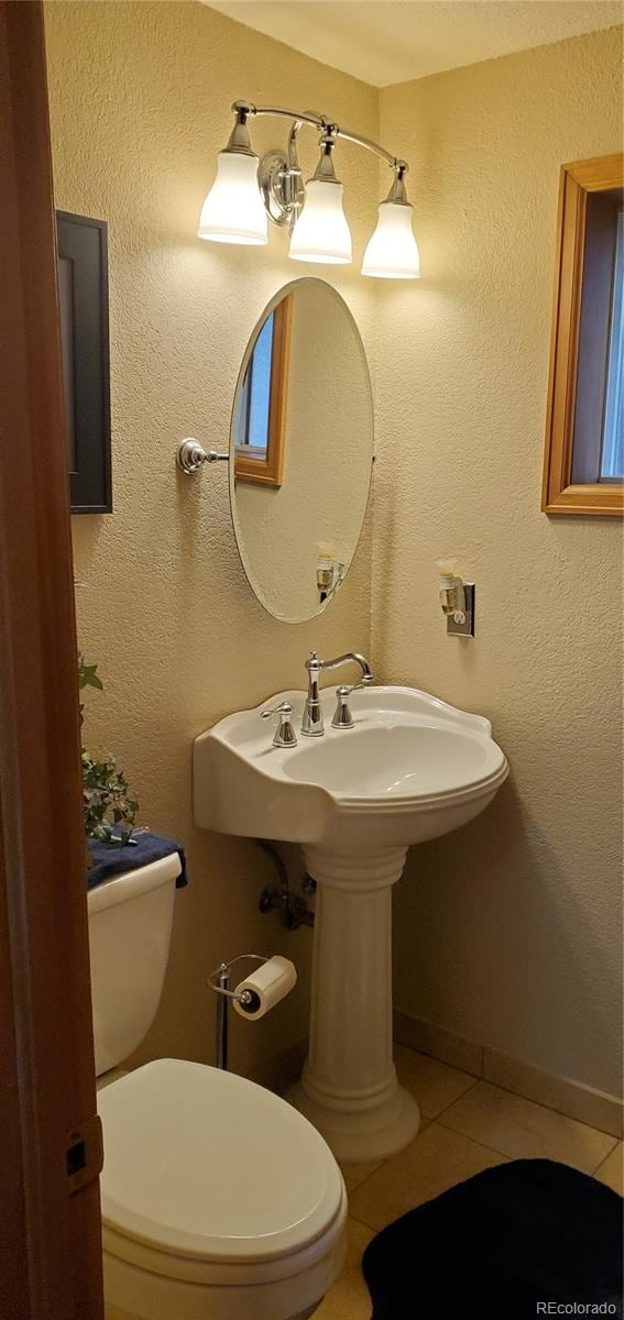 bathroom featuring toilet and tile patterned flooring