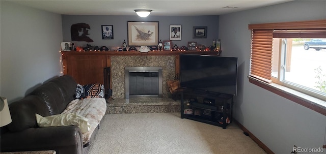 carpeted living room with a high end fireplace