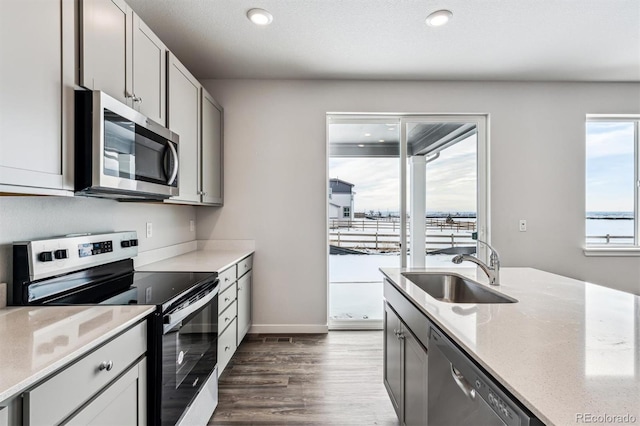 14420 Ranch St, Mead, CO 80504 - kitchen with stainless steel appliances, dark wood finished floors, light stone countertops, recessed lighting, and gray cabinets