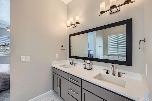 ensuite bathroom featuring double vanity, marble finish floor, ensuite bath, and a sink