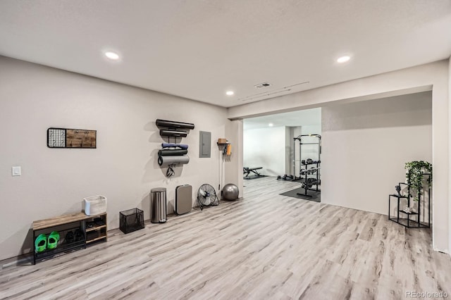 workout room with electric panel, wood finished floors, and recessed lighting