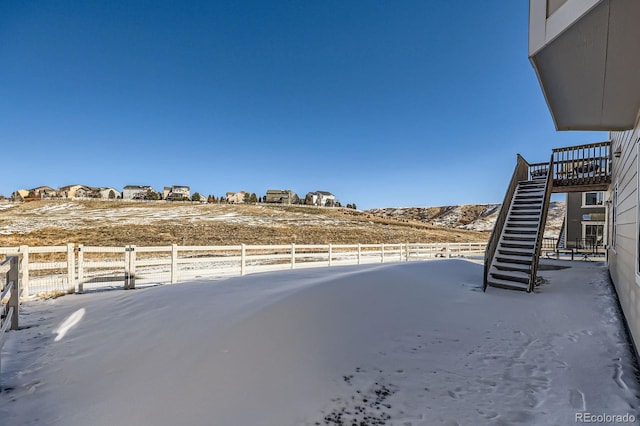 yard covered in snow featuring stairs and fence