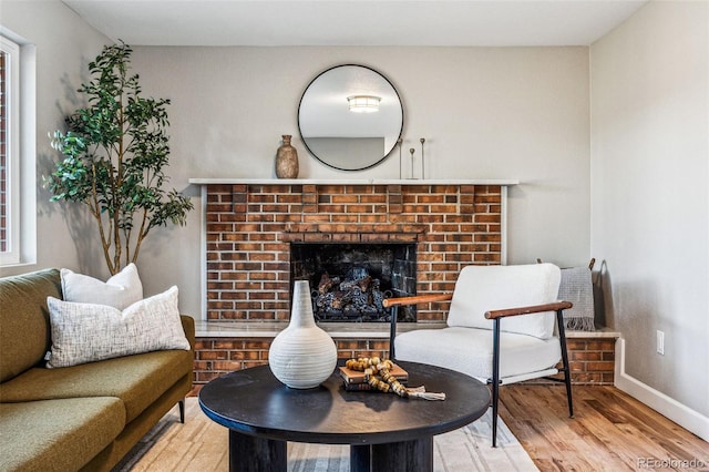 living room featuring a fireplace, wood finished floors, and baseboards