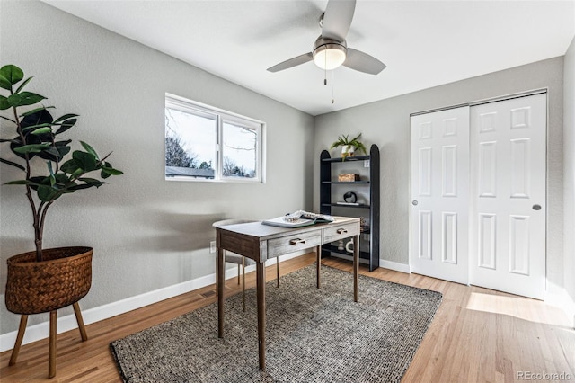 home office with ceiling fan, light wood finished floors, and baseboards