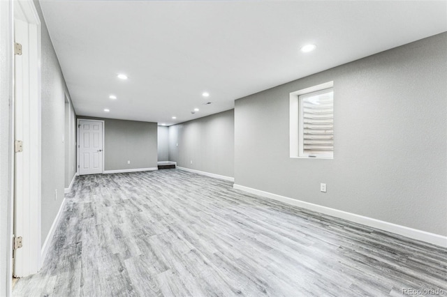 finished below grade area with light wood-style flooring, baseboards, and recessed lighting