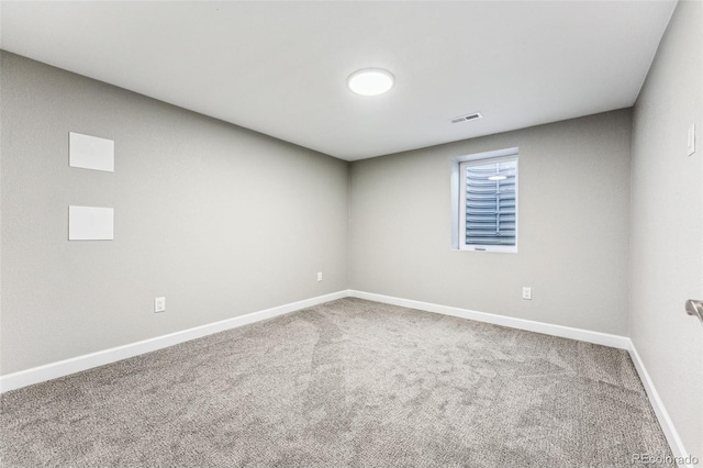 spare room featuring baseboards, visible vents, and carpet flooring