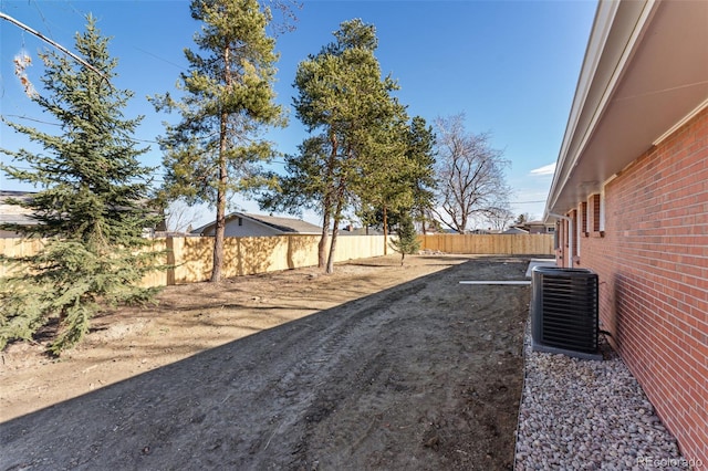 view of yard featuring a fenced backyard and central AC