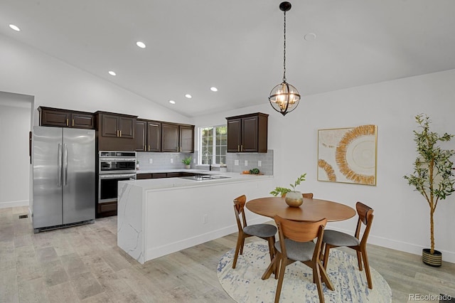 kitchen with stainless steel appliances, dark brown cabinets, lofted ceiling, light countertops, and recessed lighting