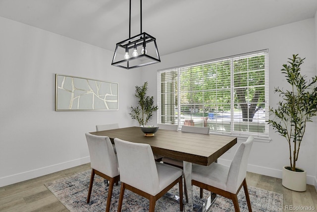dining space featuring baseboards and light wood-type flooring