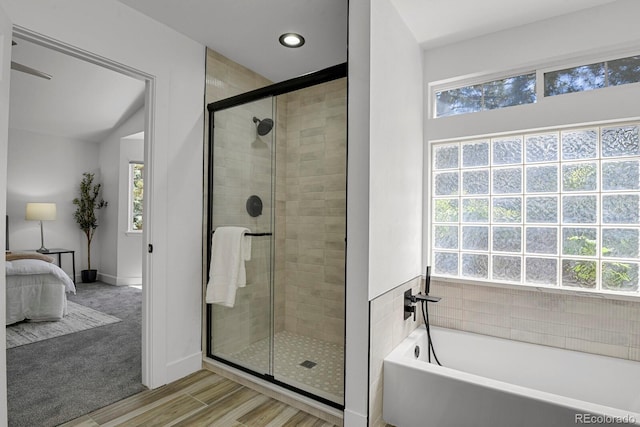 full bath with ensuite bathroom, plenty of natural light, a shower stall, a garden tub, and recessed lighting