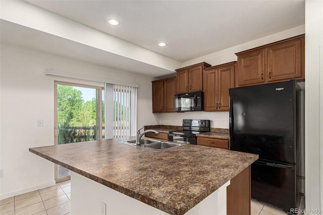 kitchen featuring black appliances, light tile patterned floors, a center island with sink, and sink