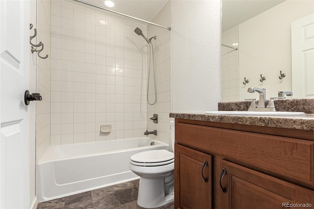 full bathroom featuring toilet, tiled shower / bath combo, and vanity