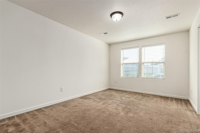 carpeted empty room with a textured ceiling