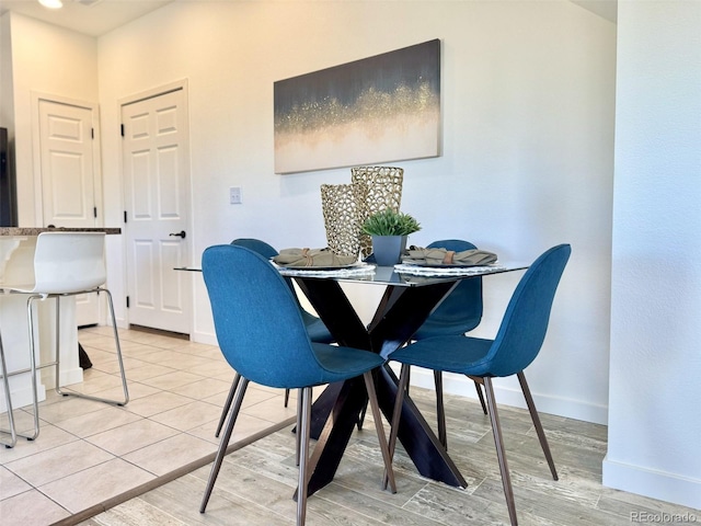 dining room featuring light wood-style floors and baseboards