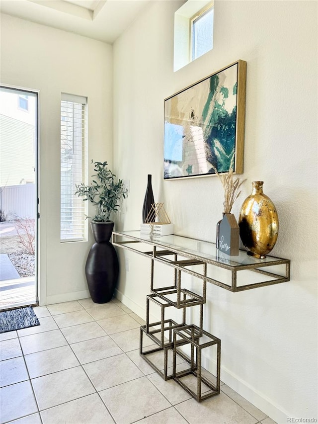 interior space with plenty of natural light, baseboards, and light tile patterned floors