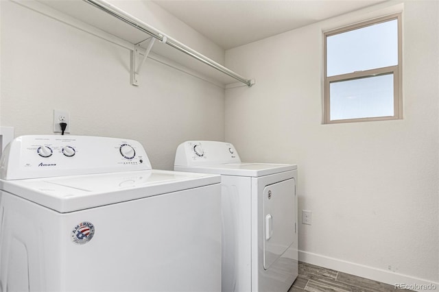 laundry room featuring laundry area, washer and clothes dryer, baseboards, and wood finished floors