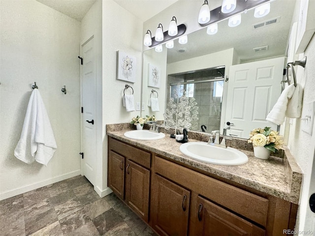 bathroom featuring baseboards, a shower stall, visible vents, and a sink