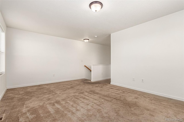 carpeted spare room featuring visible vents and baseboards