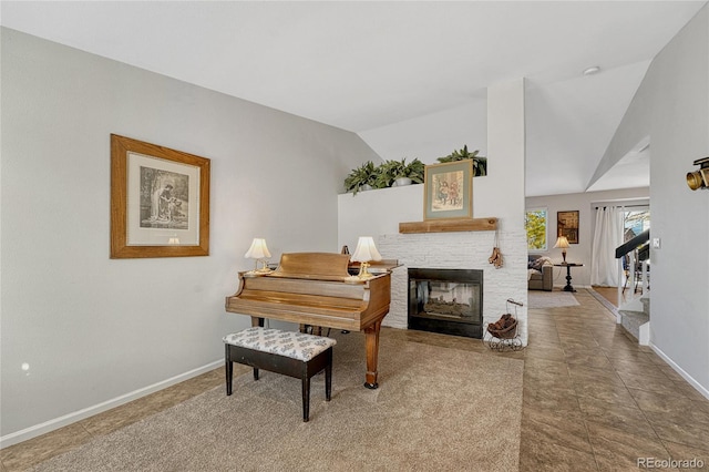 misc room featuring lofted ceiling and a brick fireplace