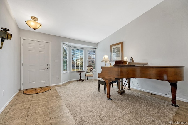 foyer entrance with light tile patterned floors and vaulted ceiling