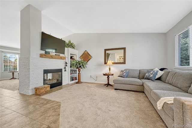 living room with lofted ceiling, a fireplace, and light colored carpet