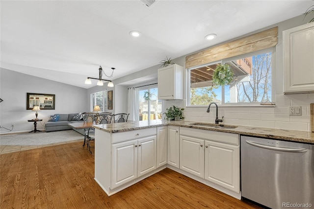 kitchen with dishwasher, sink, light stone countertops, and white cabinets