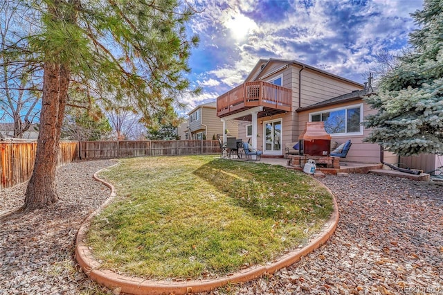 back of property featuring a wooden deck, a yard, and a patio area