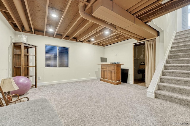 basement featuring bar and carpet floors