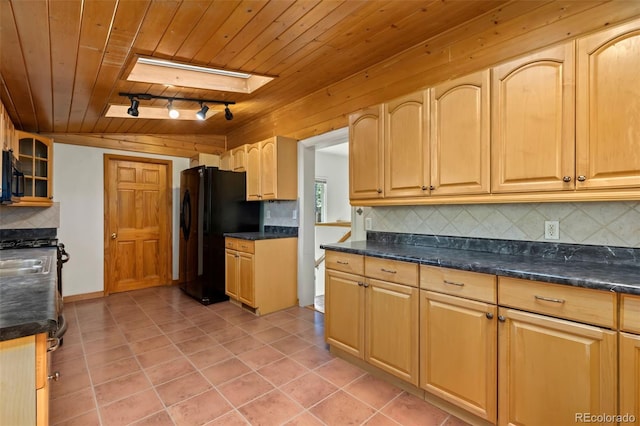 kitchen with black fridge, wooden ceiling, a skylight, and backsplash