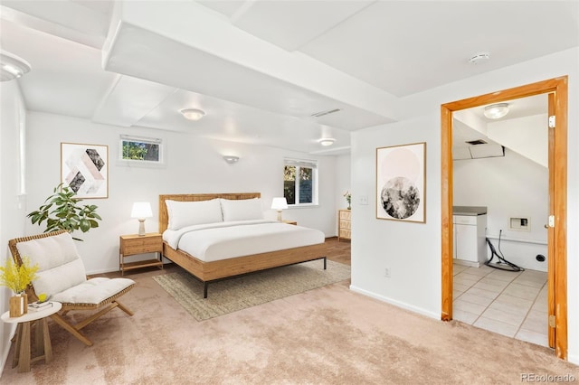 bedroom featuring light carpet and ensuite bath