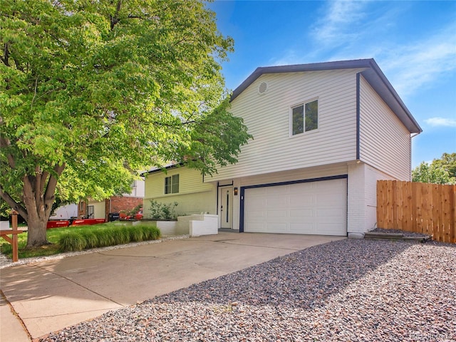 1517 S Elkhart St, Aurora, CO 80012 - split level home featuring brick siding, an attached garage, and driveway