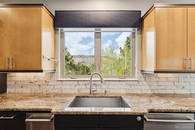kitchen with a sink, dishwasher, decorative backsplash, and light stone counters