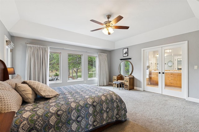 carpeted bedroom featuring french doors, a ceiling fan, a raised ceiling, and ensuite bathroom