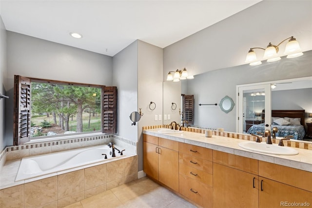 full bath featuring ensuite bath, tile patterned floors, a garden tub, and double vanity