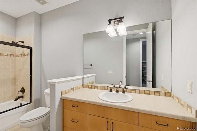 bathroom featuring toilet, vanity, and enclosed tub / shower combo