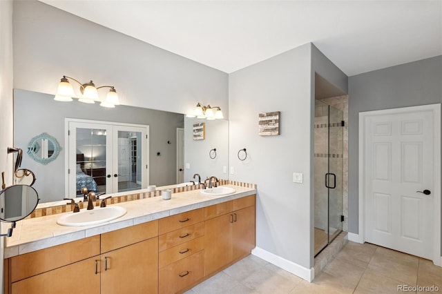 full bathroom with tile patterned flooring, a shower stall, ensuite bathroom, double vanity, and baseboards