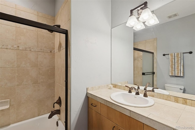 bathroom with vanity, toilet, and enclosed tub / shower combo