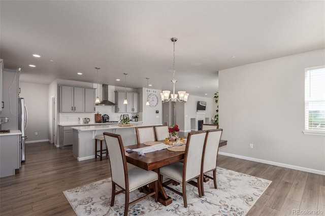 dining room featuring recessed lighting, wood finished floors, a chandelier, and baseboards
