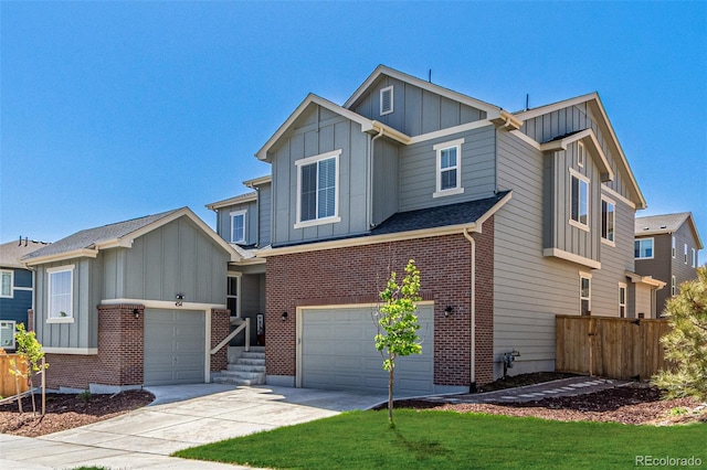 view of front of home with board and batten siding, fence, an attached garage, driveway, and brick siding