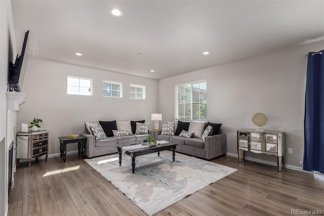 living area featuring plenty of natural light, recessed lighting, wood finished floors, and baseboards