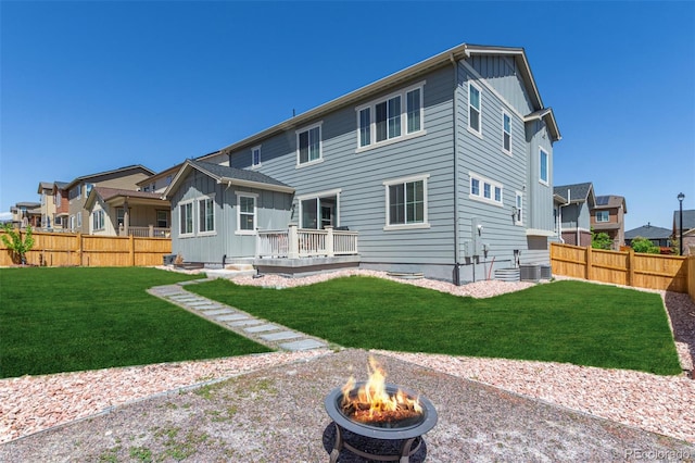 rear view of house featuring an outdoor fire pit, board and batten siding, a deck, and central AC