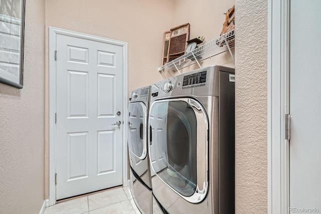 16644 Eolus Way, Broomfield, CO 80023 - laundry area with light tile patterned floors, washer and clothes dryer, and a textured wall