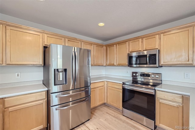 kitchen featuring light brown cabinets, light hardwood / wood-style floors, and stainless steel appliances