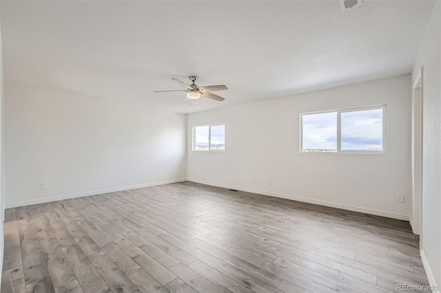 spare room featuring light hardwood / wood-style flooring, ceiling fan, and plenty of natural light